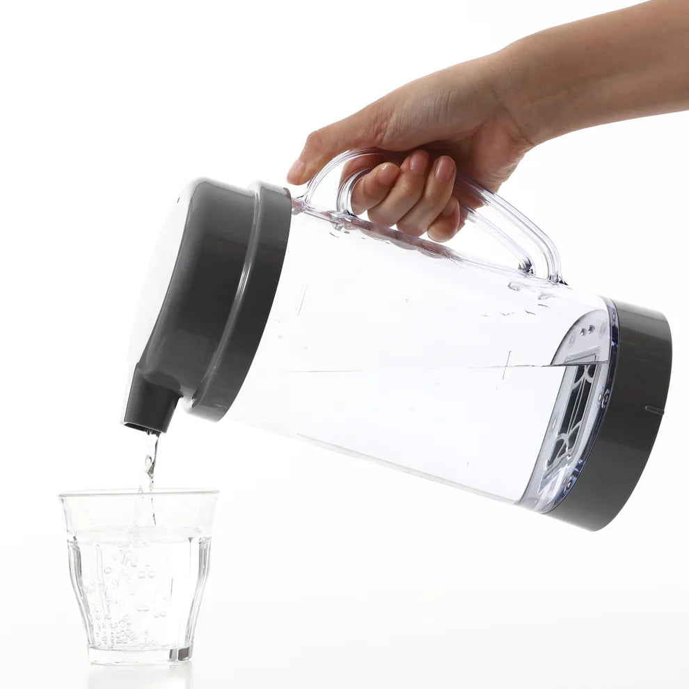 pouring hydrogen rich water from pitcher to glass